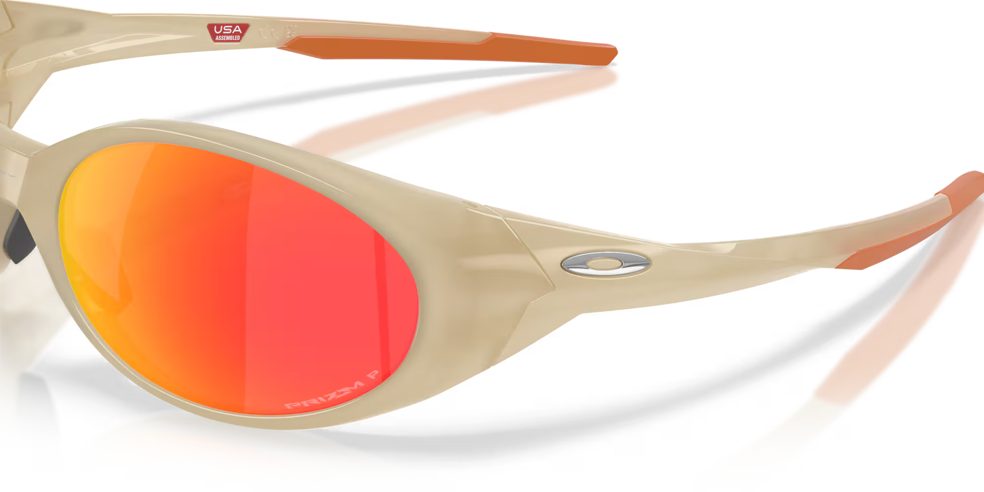 Close-up of beige Eye Jacket™ Redux Latitude Collection sunglasses by Machina - Wearable Technology, with bold oval frames, orange-red mirrored lenses, orange arm tips, and a "USA" sticker inside the arm.