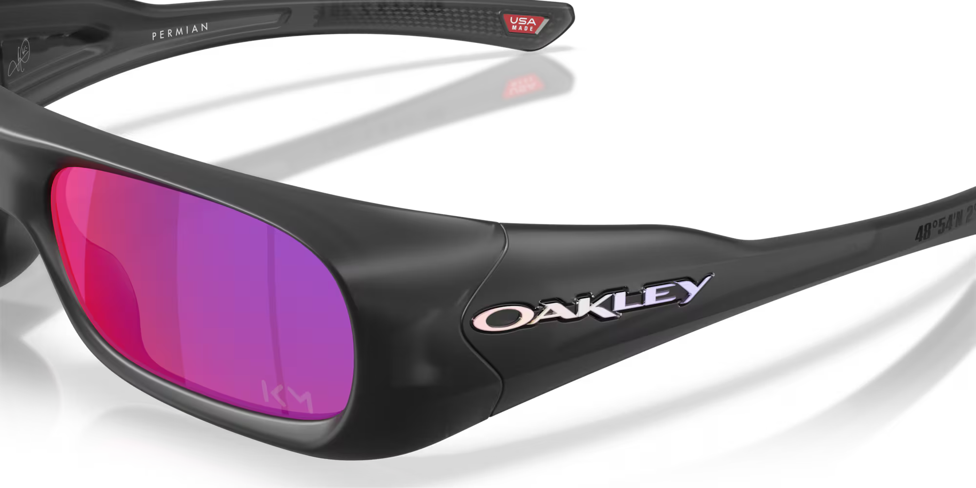 Close-up of black Machina - Wearable Technology Kylian Mbappé Signature Series Permian sunglasses with pink-purple mirrored lenses, showing the brand logo on the side and Bondy coordinates plus USA and PERIWAN text inside the arm.