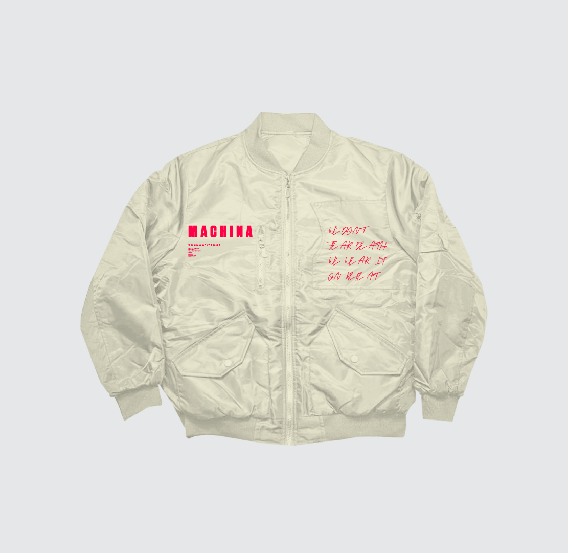 The We don't fear death Bomber Jacket by Machina – Wearable Technology is an ivory heavyweight nylon piece with pink “MACHINA” text on the chest, script details, front pockets, ribbed cuffs/hem, and spine embroidery on the back.