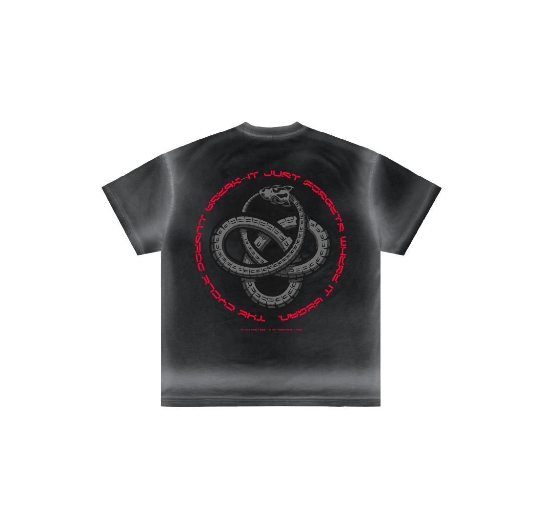 Machina - Wearable Technology’s “The cycle doesn’t break” is a black luxury cotton tee with a faded gray wash. It features a central Ouroboros serpent and red circular text: THE CYCLE DOESNT BREAK, IT JUST FORGETS WHERE. Made in Mexico.