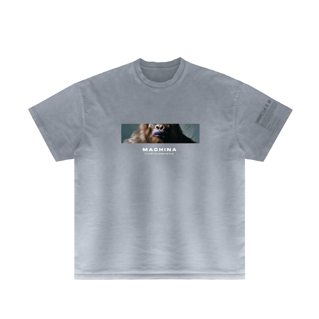A gray t-shirt from Machina - Wearable Technology features a rectangular image of a gorilla, echoing a wilderness legend, with the word 'Got Ice?' printed below. The left sleeve includes small text or graphic details for added intrigue.