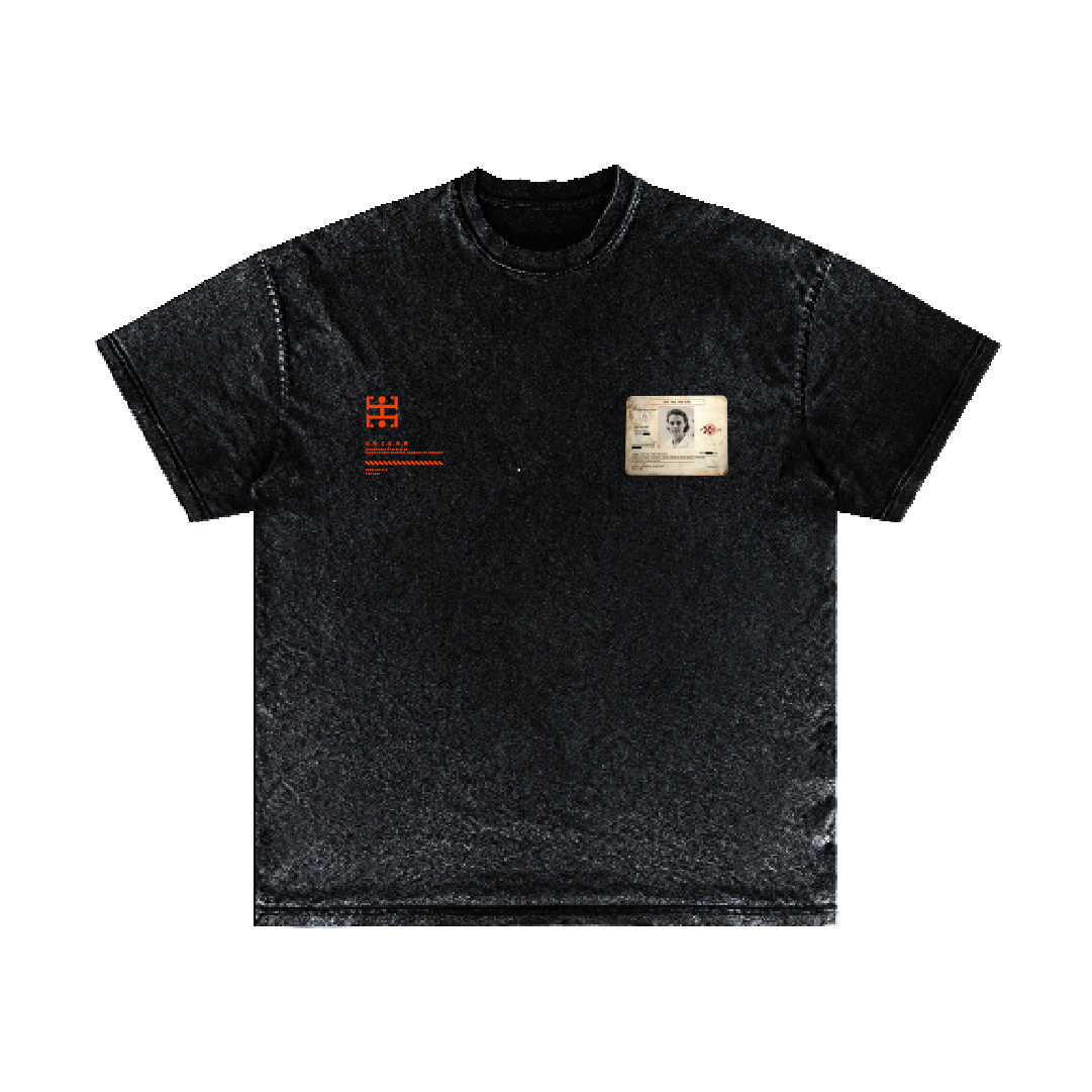 A black T-shirt from Machina - Wearable Technology features a small, abstract red design and showcases a vintage-inspired ID card graphic on the front. The shirt, named "Pioneers in Genetic Research," includes a grayscale portrait and text that hint at genetic engineering breakthroughs, giving it a retro aesthetic.
