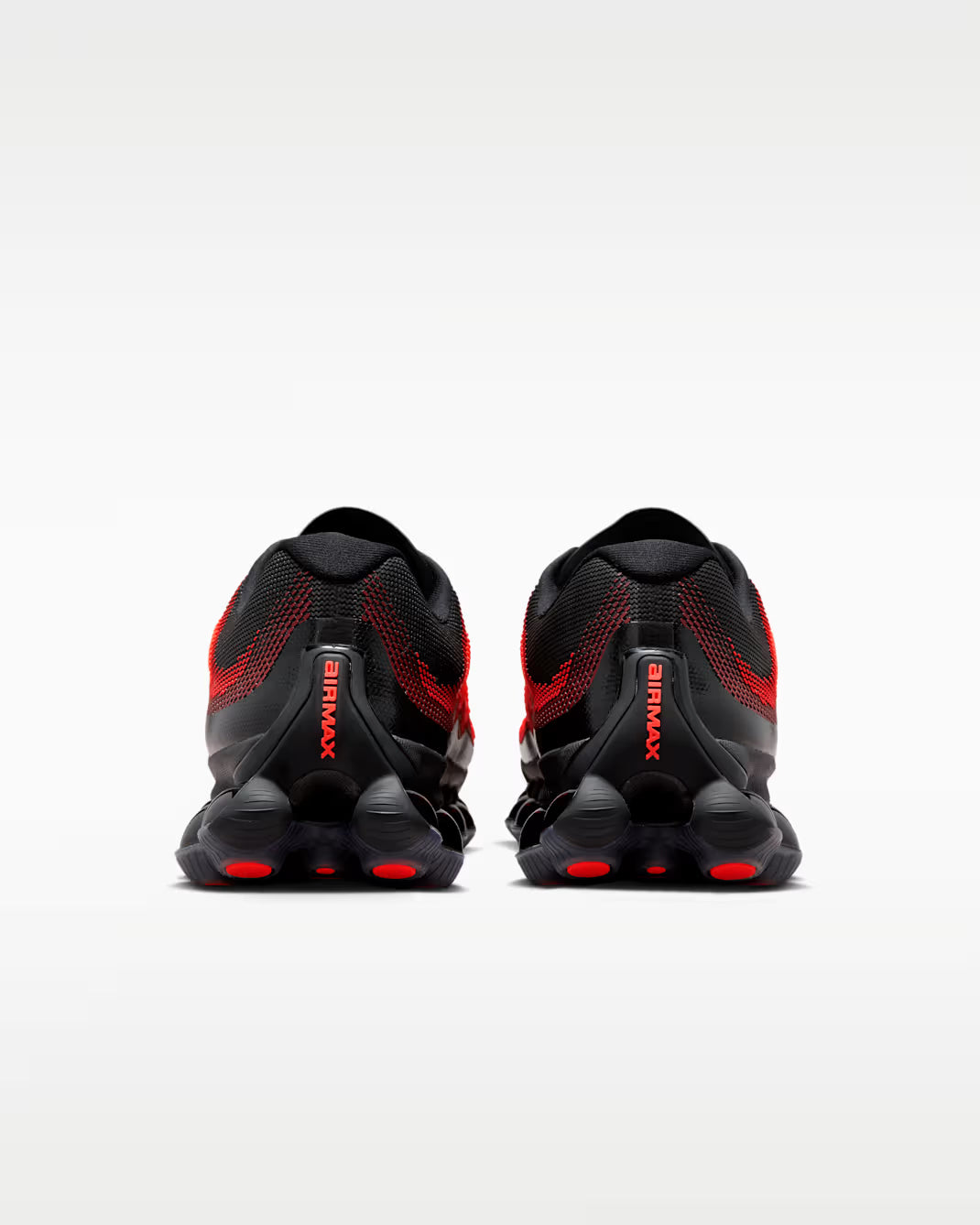 A pair of black Machina Wearable Technology Air Liquid Max 'Bright Crimson Fire Red' sneakers, shown from the back on a plain white background. The word AIRMAX appears in red text on each heel.