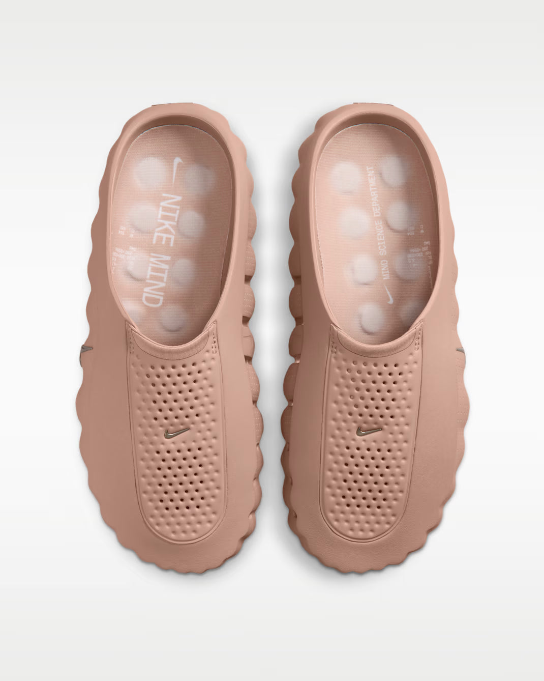 A pair of mauve Mind 001 slip-on mules by Machina Wearable Technology featuring a perforated upper, a thick grooved sole, and a small logo on the top.