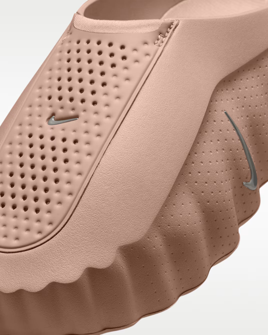 Close-up of a dusty pink Machina Wearable Technology Mind 001 slip-on sensory sneaker with a perforated upper and a thick, textured side sole featuring small swoosh logos.