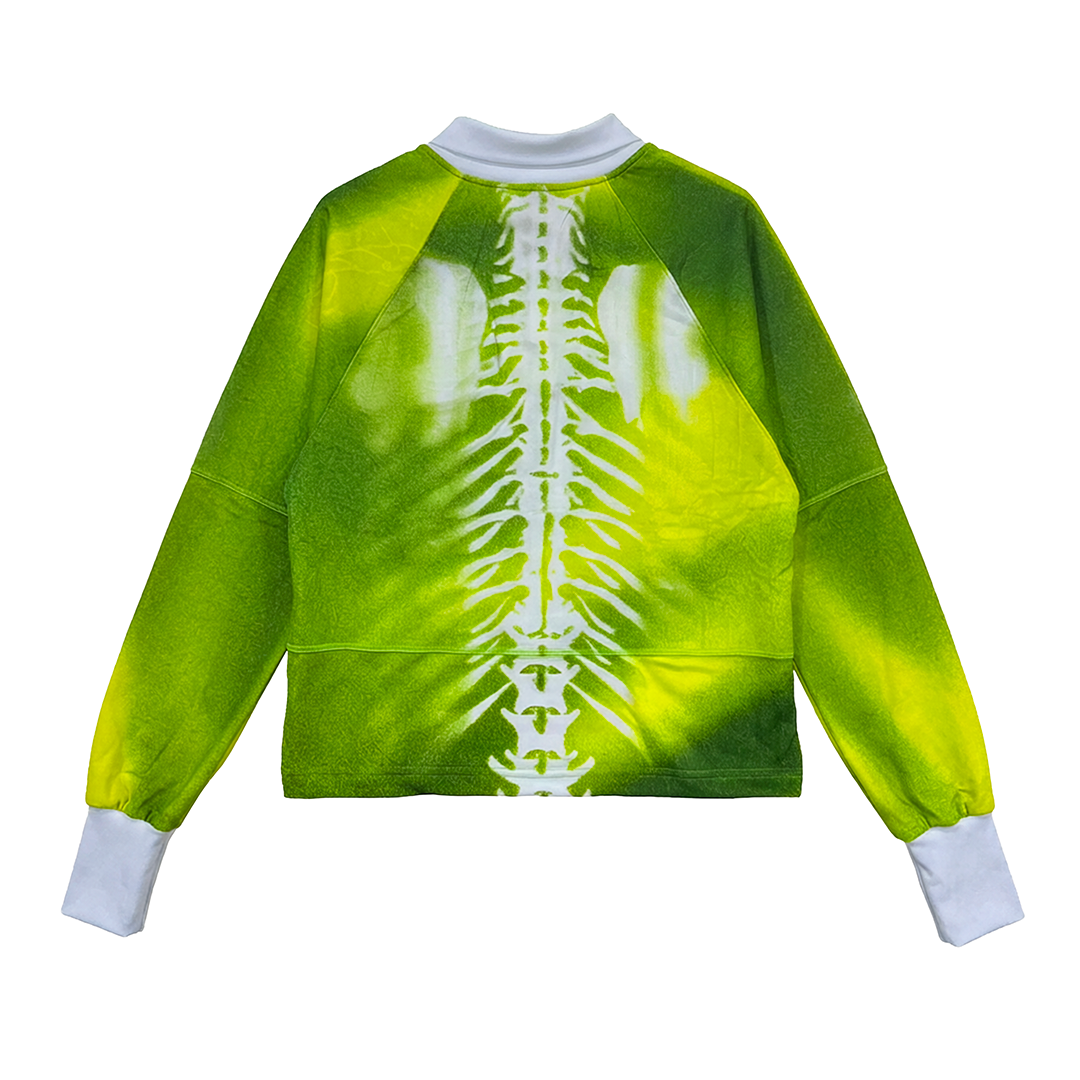 The Old Lion by Machina - Wearable Technology is a long-sleeve shirt with a green-yellow gradient, inspired by classic Cameroon football jerseys. It features a large white spine graphic on the back plus white cuffs and collar.