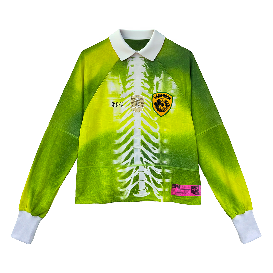 The Old Lion by Machina - Wearable Technology is a long-sleeved green and yellow shirt with a white collar, graphic ribcage, Cameroon soccer badge, and various logos, inspired by the Cameroon football jersey.