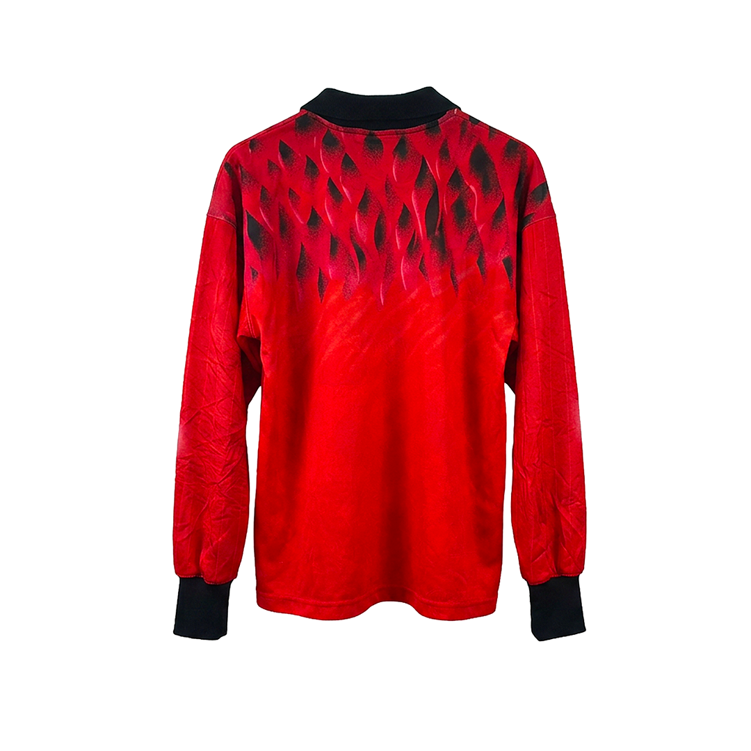 The SOPA MAGICA [Hungría] by Machina - Wearable Technology is a long-sleeve red shirt with black cuffs and collar, inspired by the 1954 Hungarian Golden Team jersey, and features a bold black pattern on the upper back and shoulders.
