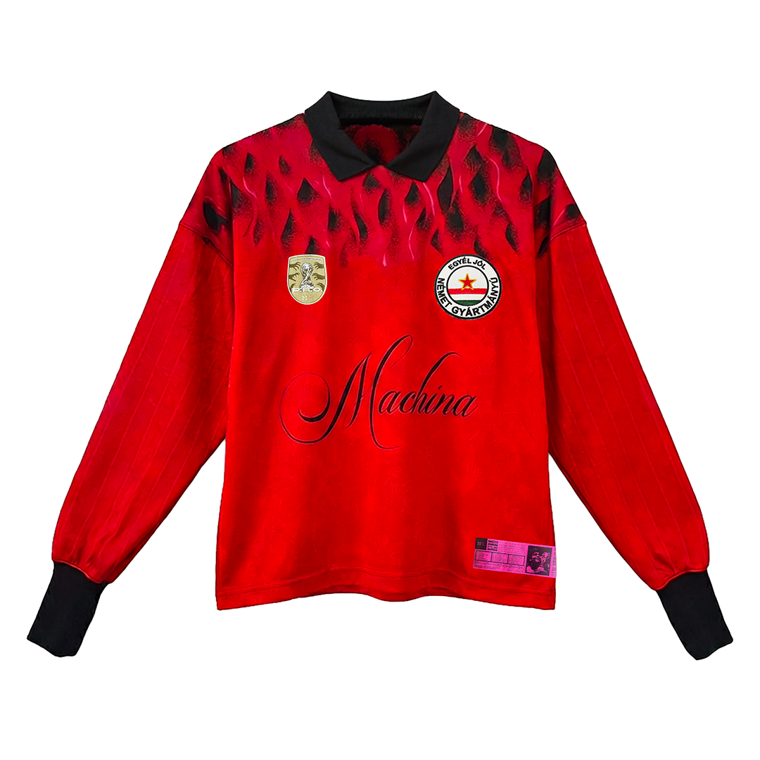 The SOPA MAGICA [Hungría] long-sleeve red soccer jersey by Machina features black accents, a black collar, shield and round badges on the chest, Machina script across the front, and a patterned design inspired by Hungary’s Golden Team.