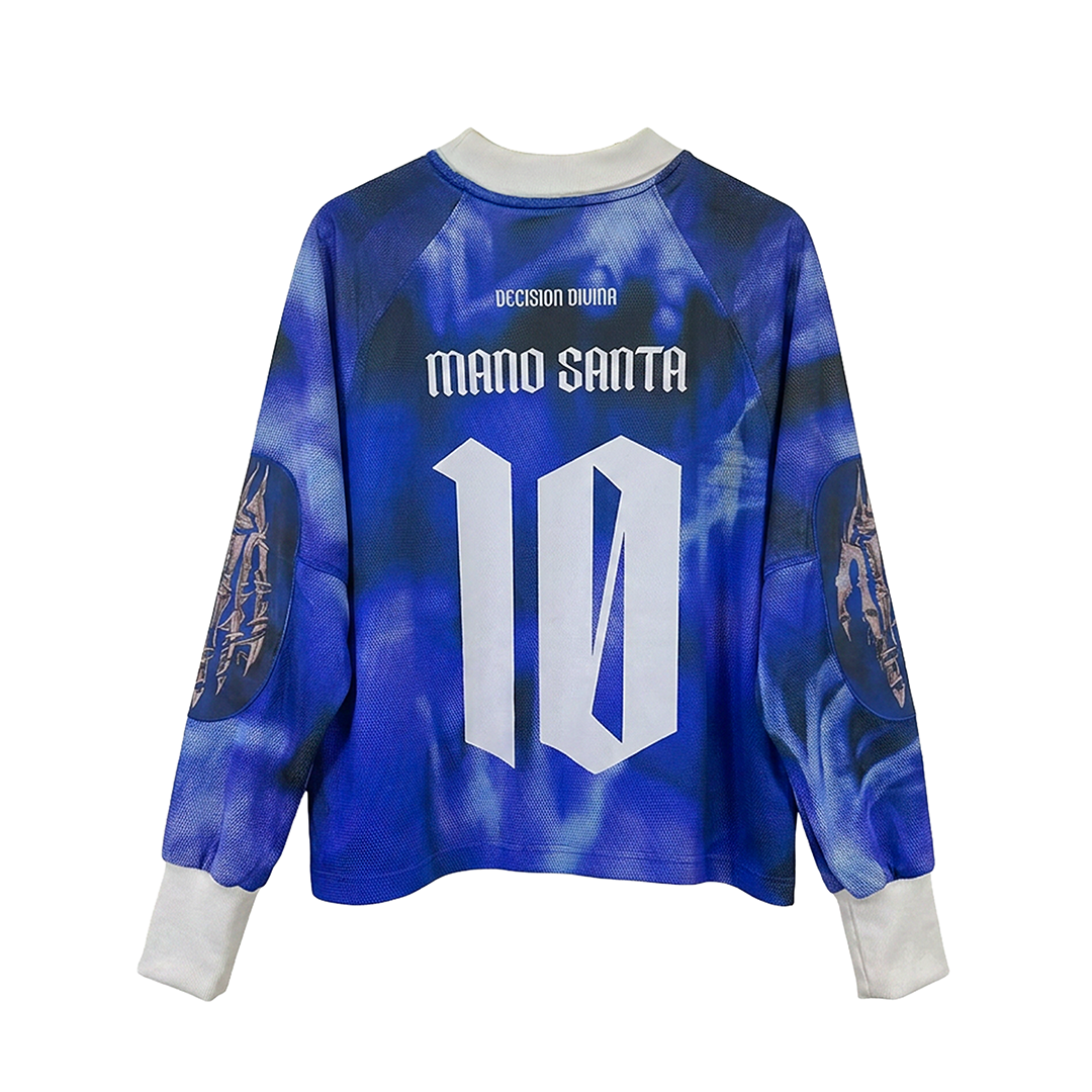 The LA MANO DE DIOS LS by Machina - Wearable Technology is a blue and white long-sleeve shirt with "MANO SANTA" and number 10 on the back, "VOCISION DIVINA" at the top, and sleeve graphics inspired by the Hand of God jersey.