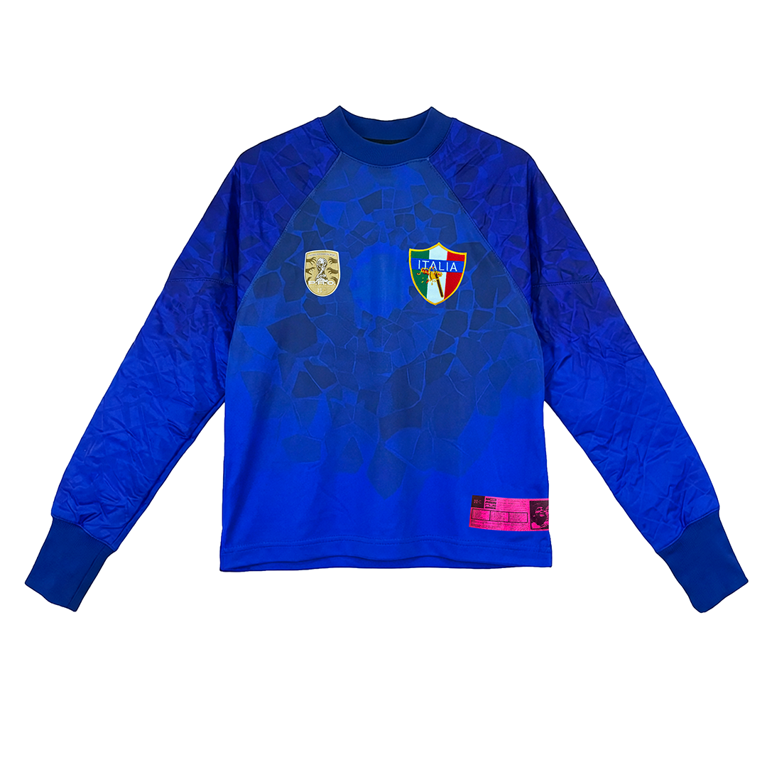 The TESTATA by Machina - Wearable Technology is a blue long-sleeve Italy soccer jersey with geometric patterns, Italia crest, gold badge, and pink label—honoring Italy’s 2006 FIFA World Cup legacy.