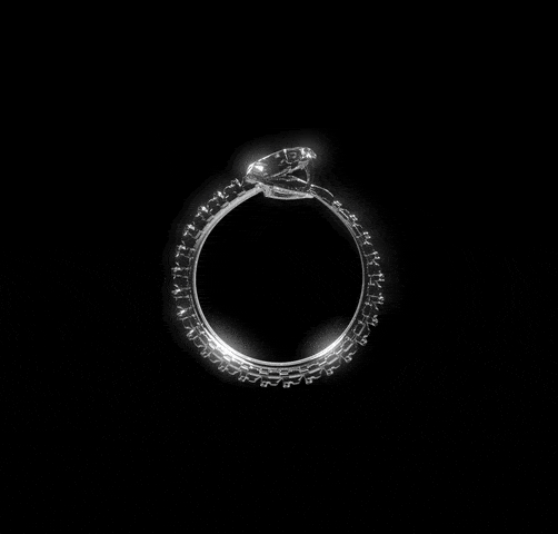 The Ouroboros Ring by Machina - Wearable Technology slowly rotates against a black backdrop, showcasing a striking central stone and smaller diamonds along the band, echoing the refined style of biomechanical jewelry.