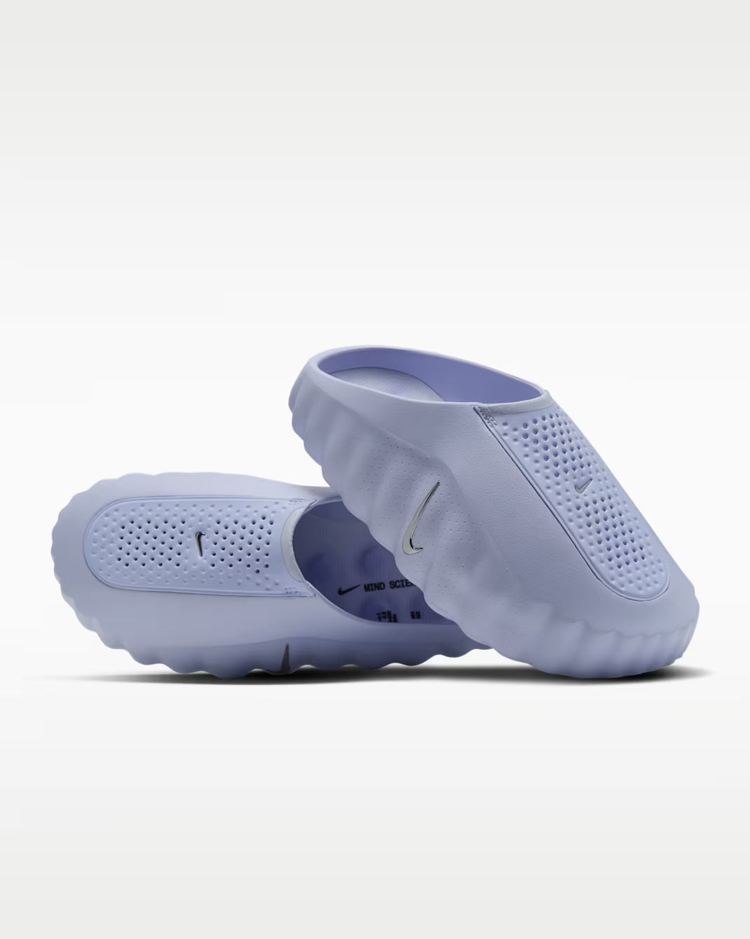 A pair of light purple Mind 001 sensory sneakers by Machina Wearable Technology in a slip-on clog style with perforated toe boxes and a textured, wavy sole.