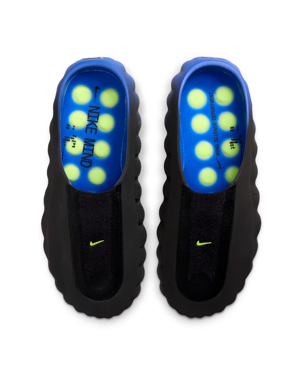 Top-down view of black Machina Wearable Technology Mind 001 Flyknit Hyper Royal slip-ons with bright blue insoles, yellow sensory nodes, and green logos. Text: NIKE MIND and WILD DESIGN SUPPORT.