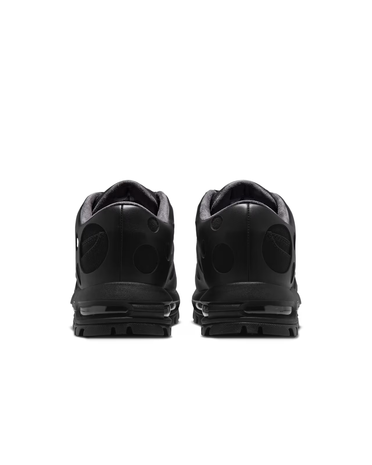 A pair of Air Max Goadome Low [Black] sneakers by Machina Wearable Technology is seen from the back, showcasing their heels and soles. These shoes feature a subtle textured pattern with reflective accents and visible Air cushioning in the soles, offering a blend of comfort and durability inspired by the iconic Nike Air Max Goadome style—ideal for everyday wear.