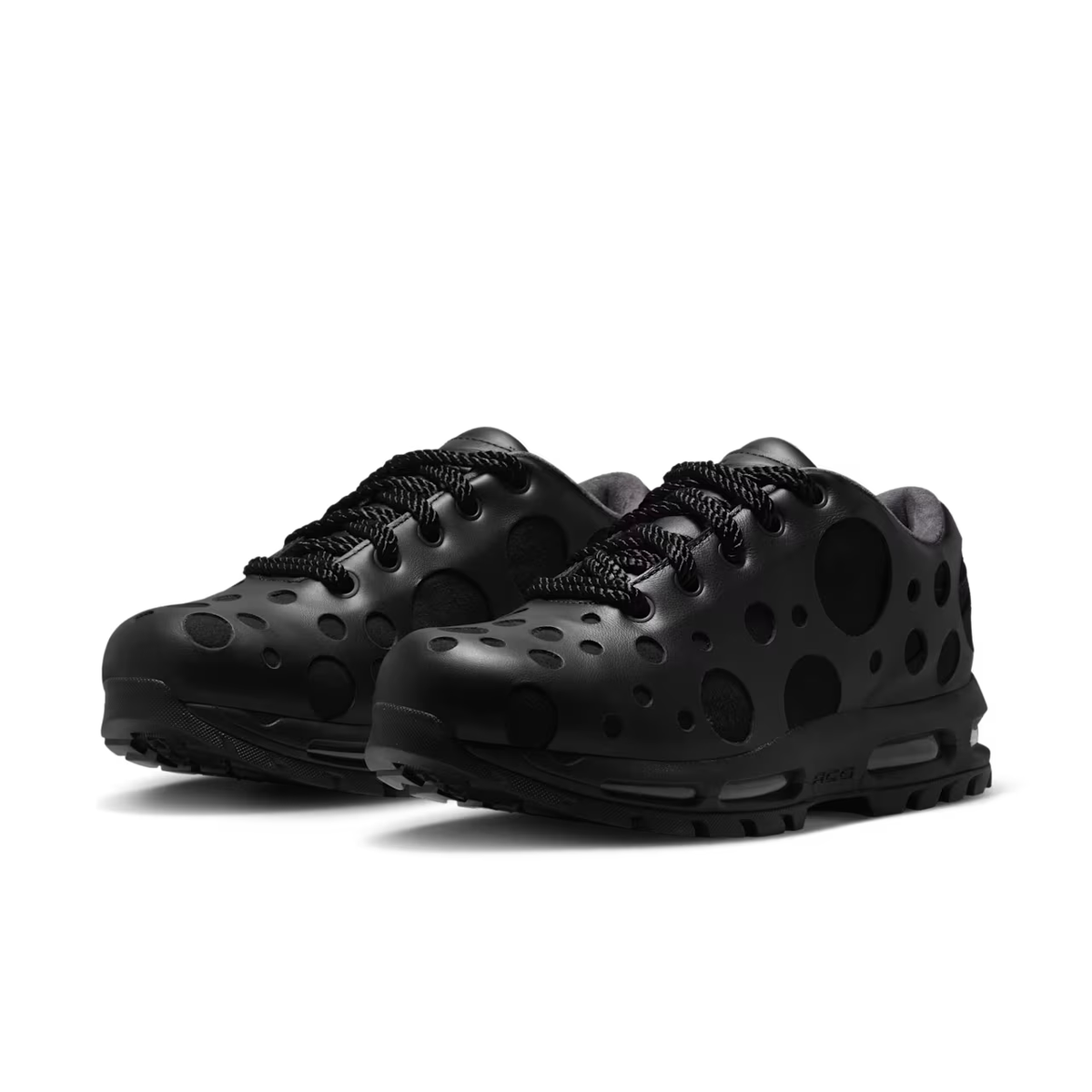 Introducing the Air Max Goadome Low [Black] by Machina Wearable Technology: a pair of black sneakers with circular cutout holes, textured laces, and thick, sculpted soles. Featuring air cushioning inspired by the Nike Air Max Goadome, these shoes showcase a modern, futuristic design and a matte finish.