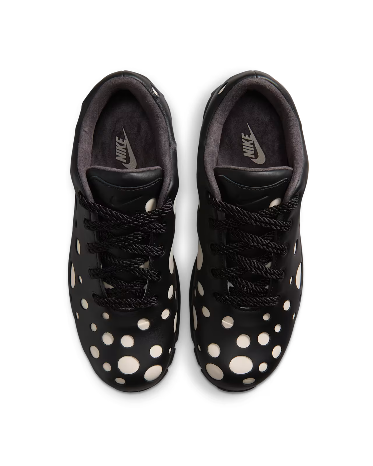 Top view of a pair of Machina Wearable Technology Air Max Goadome Low sneakers in Light Orewood Brown and Black, featuring large white circular cutouts on the upper that reveal a white layer underneath. The shoes showcase neutral colors with black laces, a dark interior lining, and the brand logo visible on the insoles. Inspired by outdoor boot designs, this style channels elements seen in silhouettes like the Nike Air Max Goadome Low.