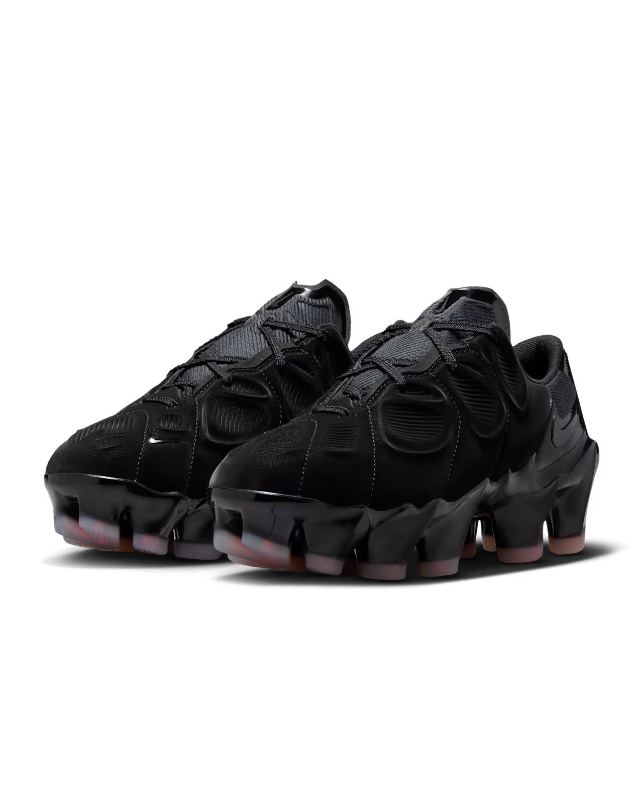 A pair of black and Flash Crimson athletic sneakers by Machina Wearable Technology, inspired by the Nike First Sight Mirage, with textured uppers, segmented soles, glossy accents, and a modern futuristic design.