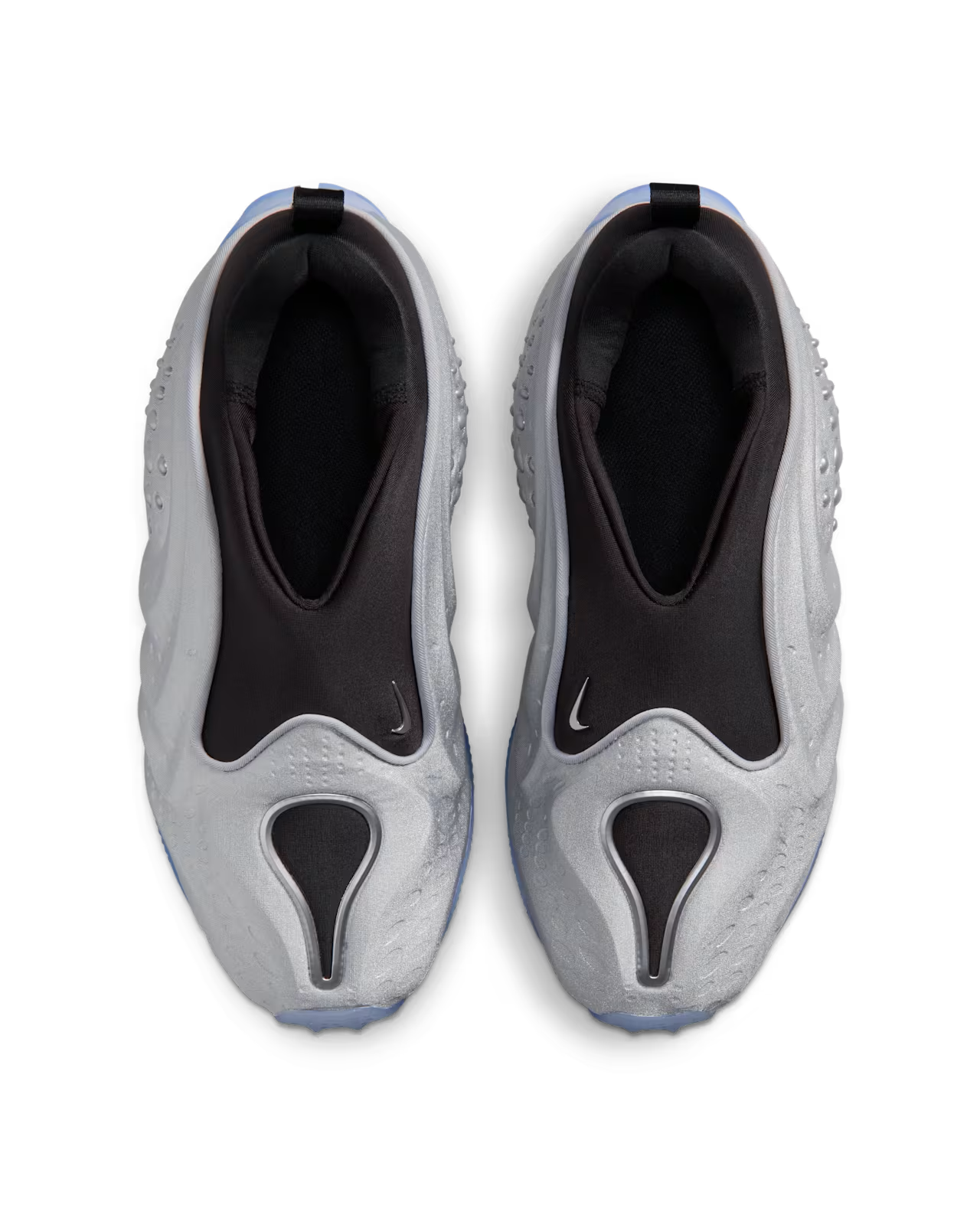 Top view of a pair of Machina Wearable Technology First Sight Shadow Low sneakers in metallic silver and black, featuring a sleek slip-on design, glossy finish, textured surfaces, and subtle logos near the opening—ideal women’s lifestyle footwear for everyday style.