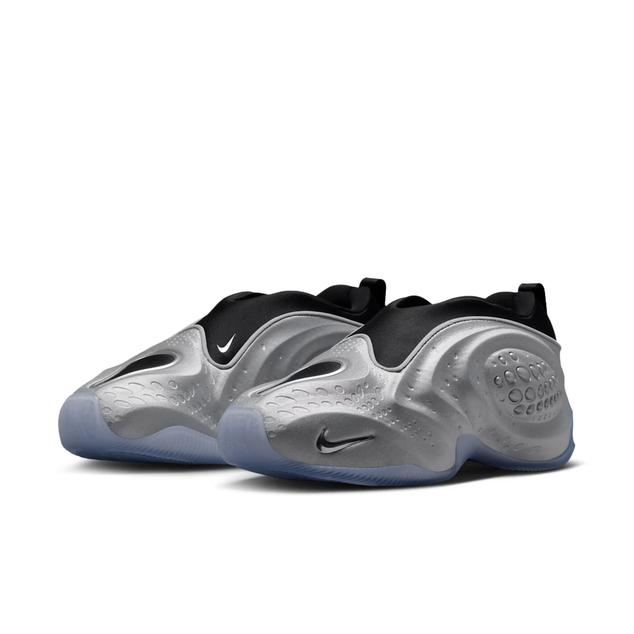 A pair of futuristic Machina Wearable Technology First Sight Shadow Low sneakers in metallic silver and black, featuring wavy metallic sides, black uppers, icy blue translucent soles, and subtle logos on the side and toe—perfect for elevating women’s lifestyle footwear collections.