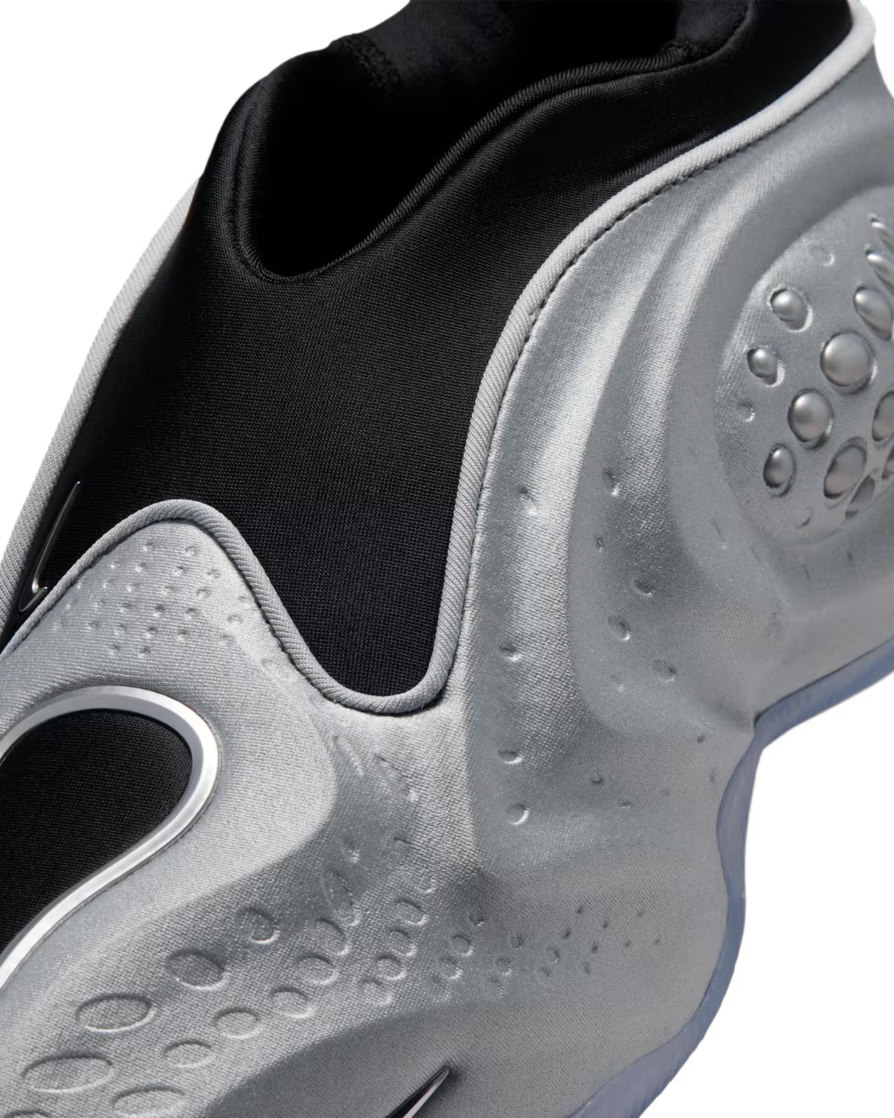 Close-up of the Machina Wearable Technology First Sight Shadow Low in Metallic Silver and Black, a futuristic women’s lifestyle sneaker featuring a silver athletic shoe with a black fabric upper, textured and dimpled sides, and a sleek, modern design.