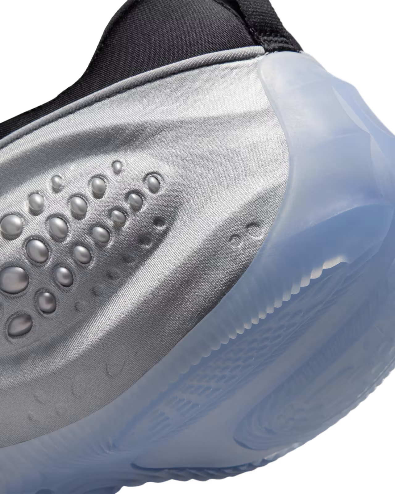 Close-up of the Machina Wearable Technology First Sight Shadow Low sneaker in Metallic Silver and Black—a striking women’s lifestyle shoe featuring a silver side panel with textured oval bumps, a translucent icy blue sole, and black upper fabric details—an eye-catching example of metallic silver sneakers.