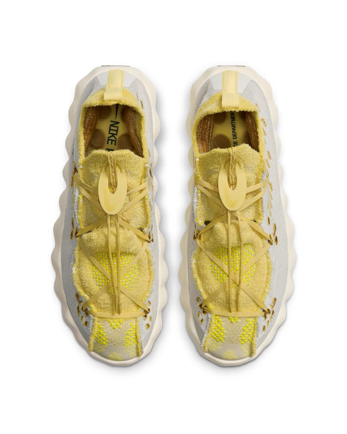 Top view of a pair of Light Bone and Saturn Gold Mind 002 sneakers by Machina Wearable Technology with wavy, textured soles, mesh fabric, and a unique toggle lacing system on a white background—perfect lifestyle footwear for those who appreciate innovative sneaker design.