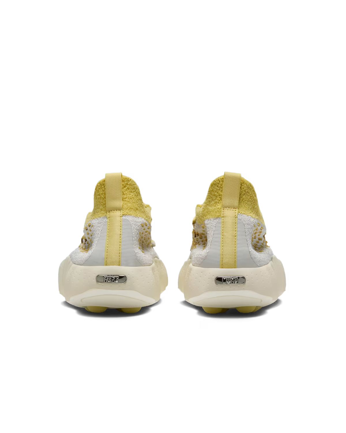 Rear view of a pair of Machina Wearable Technology Mind 002 Light Bone and Saturn Gold sneakers with textured uppers, pull tabs, and metallic branding on the cream-colored soles—a modern lifestyle silhouette.