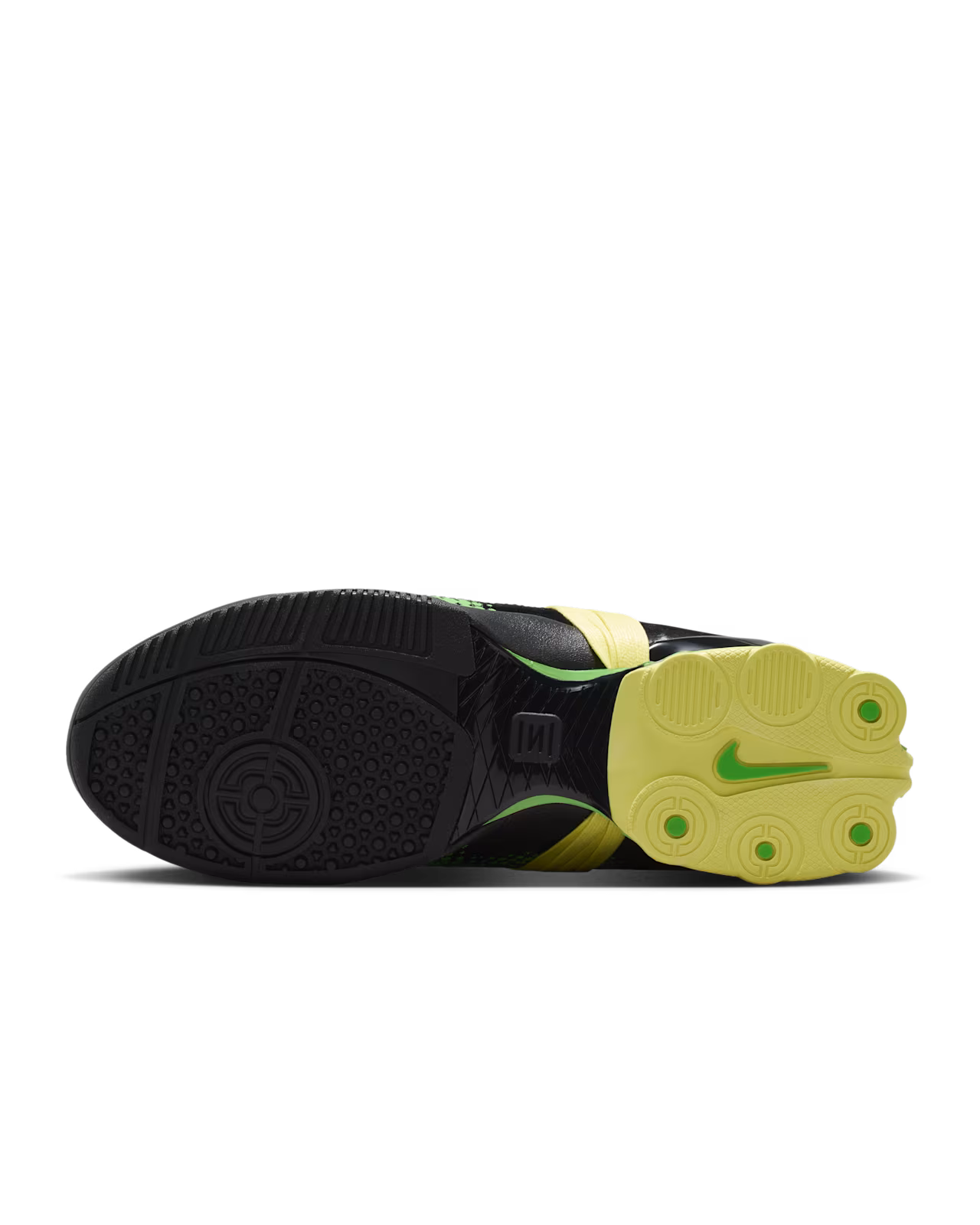 The image features the sole of the Machina Wearable Technology Total 90 Shox Magia Black and Yellow Diamond soccer cleat, showcasing a distinctive black and yellow pattern with four yellow studs and a green logo on the bottom, closely mirroring the classic design of the original model.