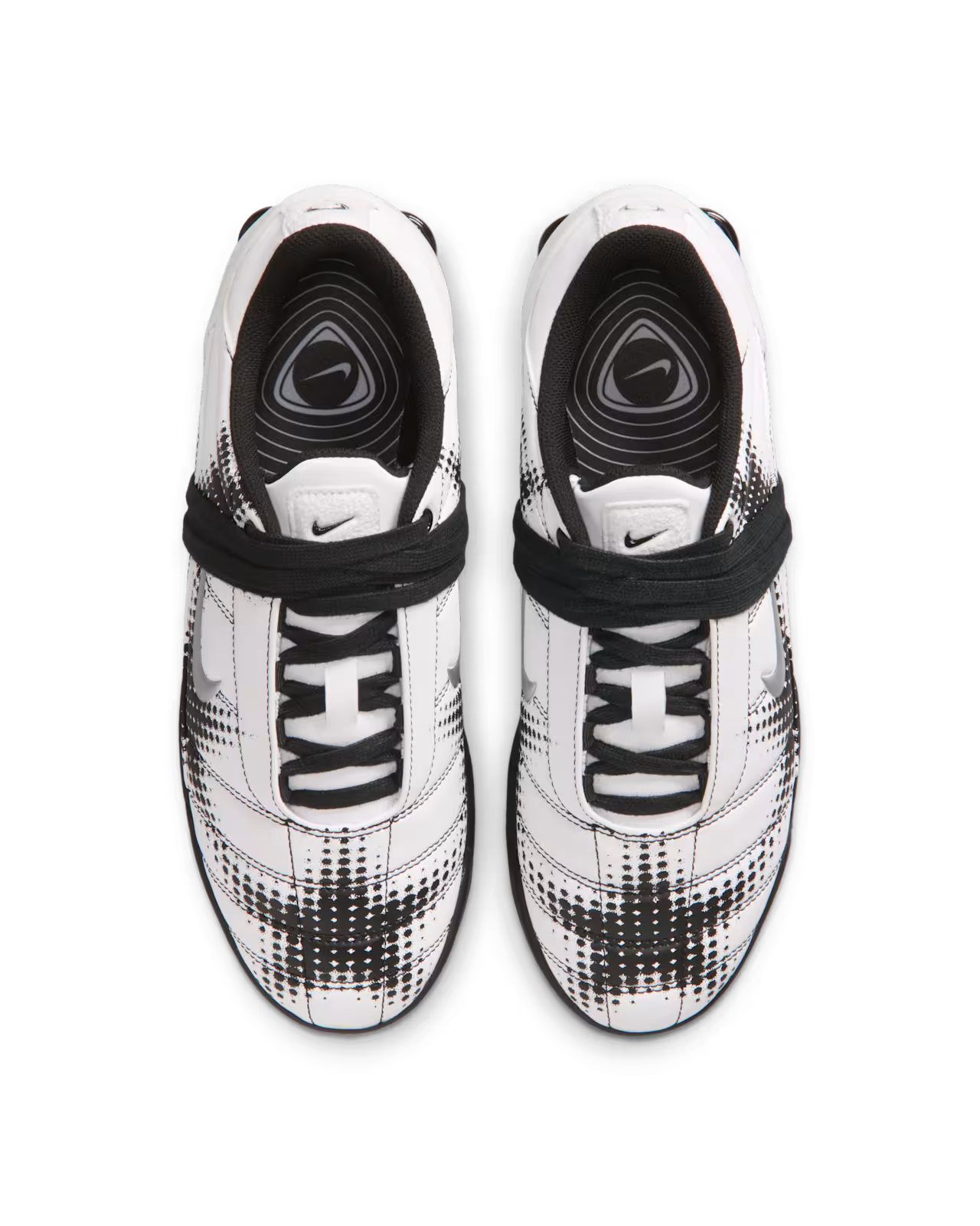 A pair of Machina Wearable Technology Total 90 Shox Magia White and Black football shoes, featuring black pixelated patterns and black laces, are viewed from above on a plain white background.