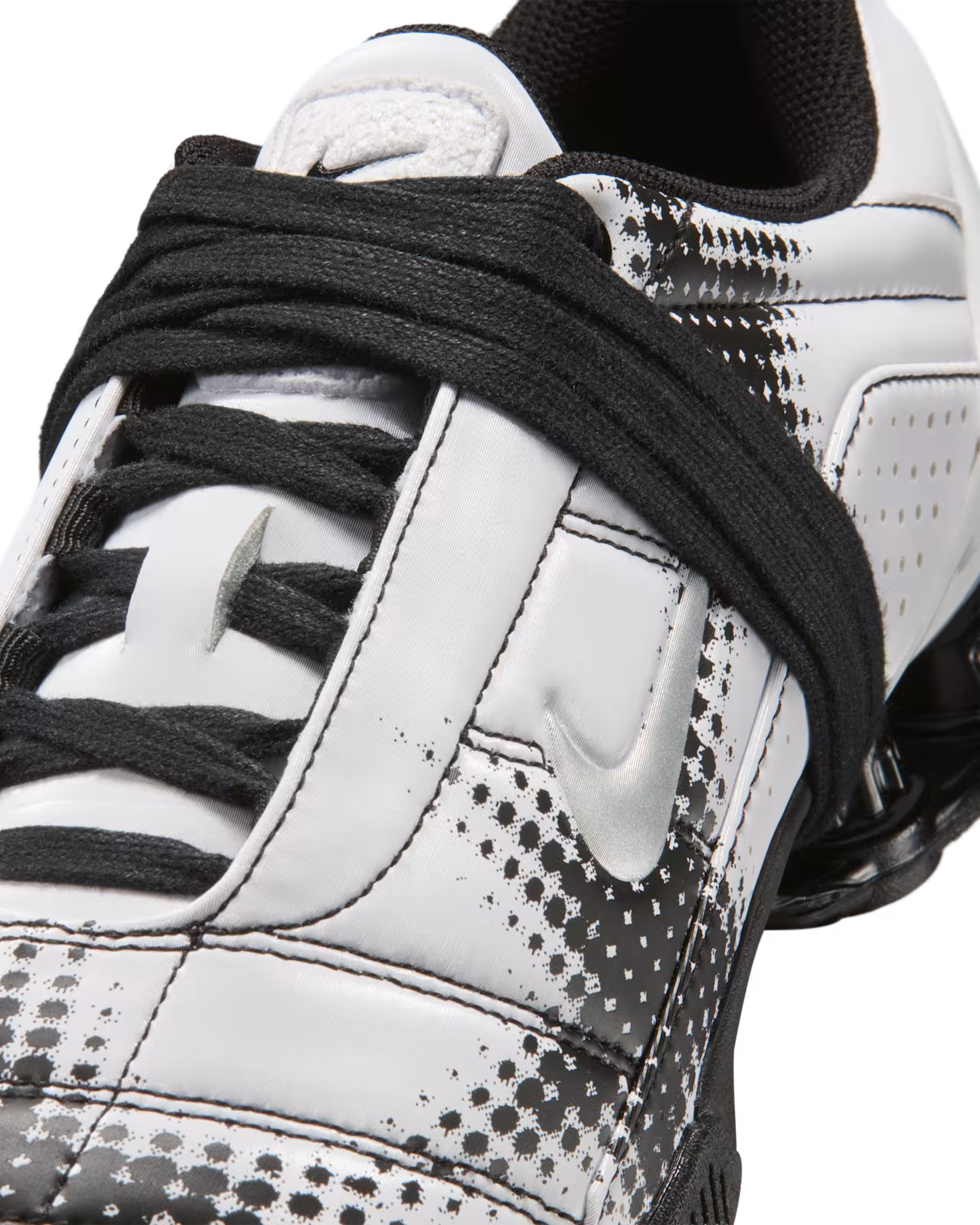 Close-up of a white and black Machina Wearable Technology Total 90 Shox Magia shoe with black laces, featuring a textured dotted design on the side and the signature logo.