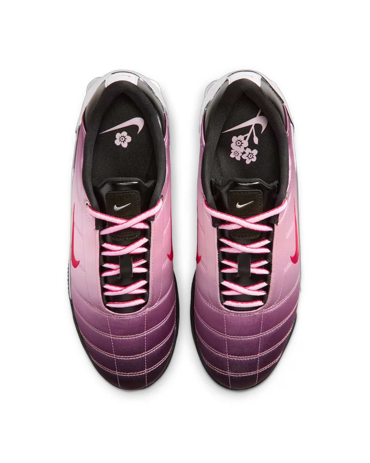 Top view of Machina Wearable Technology Total 90 Shox Magia x Forget me nots sneakers with gradient pink and purple design, pink laces, black tongues with a small logo, and floral-print black insoles inspired by classic satin upper football shoes.
