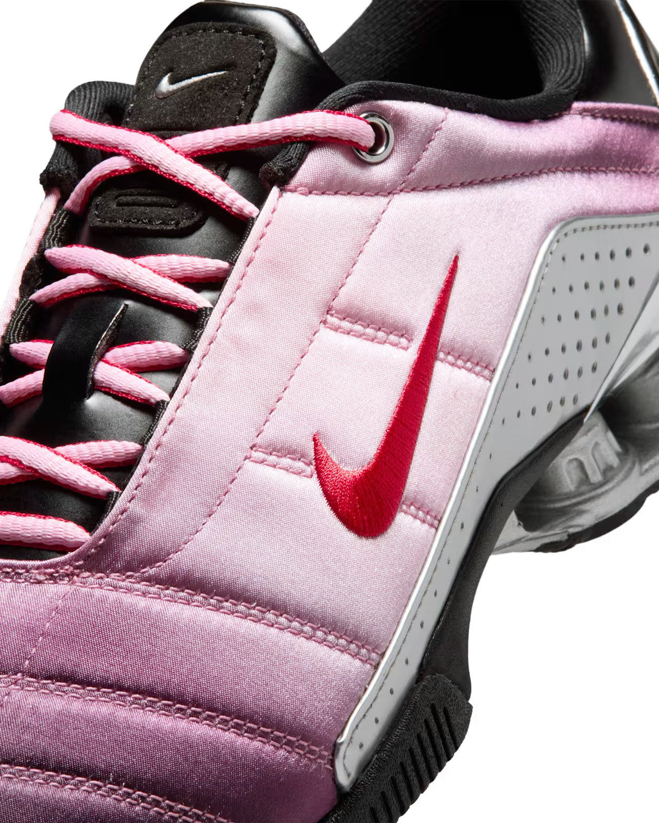 Close-up of the Machina Wearable Technology Total 90 Shox Magia x Forget me nots sneaker, featuring pink and white tones, red accents, floral details, and a bold black tongue for a stylish finish.