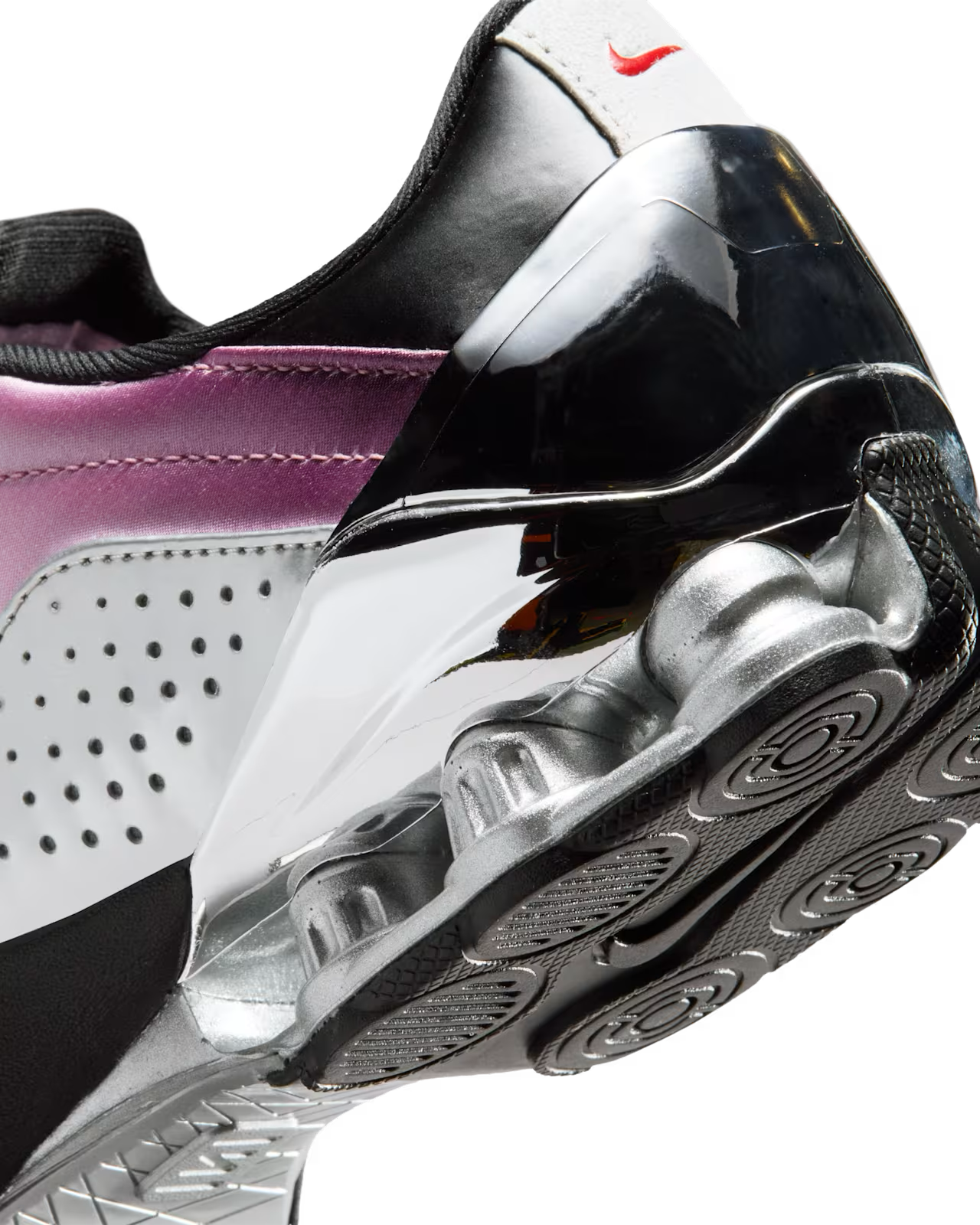 Close-up of the Total 90 Shox Magia x Forget me nots by Machina Wearable Technology, showcasing a shiny metallic heel, circular textured sole, perforated white upper with purple gradient accents, and a small red logo on the heel tab.