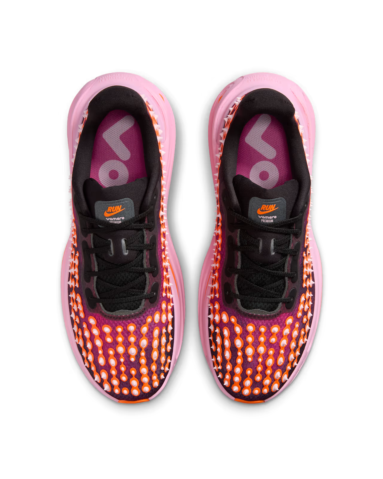 A pair of Machina Wearable Technology’s Nike Vomero Premium “Otaku Approved” running shoes with black laces, purple and pink soles, and orange dot patterns on the uppers. Built on the ZoomX platform for responsive support, these maximum-cushion running shoes feature purple insoles with the word RUN visible in white letters.