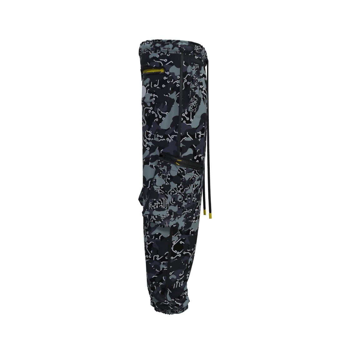 Side view of the Machina - Wearable Technology's Black Mamba Technical Pants, displaying a black, dark green, and white abstract camo pattern. These techwear trousers come with adjustable drawstrings, zippered pockets, and are finished with a fitted elastic band at the ankles.