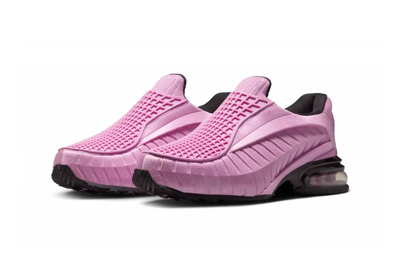 A pair of Machina Wearable Technology Nike Air Max Dolce "Light Magenta" lifestyle sneakers, featuring textured pink slip-on uppers, black soles, and visible air cushioning in the heels, displayed on a white background.