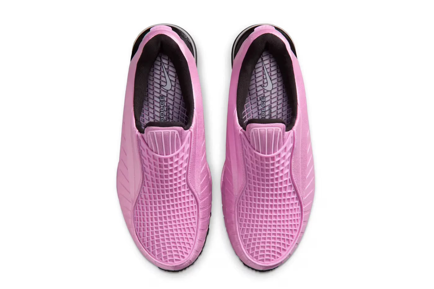 A pair of Machina Wearable Technology Nike Air Max Dolce "Light Magenta" slip-on sneakers with textured uppers and black-and-white soles, styled as a fashionable lifestyle sneaker and photographed from above on a white background.