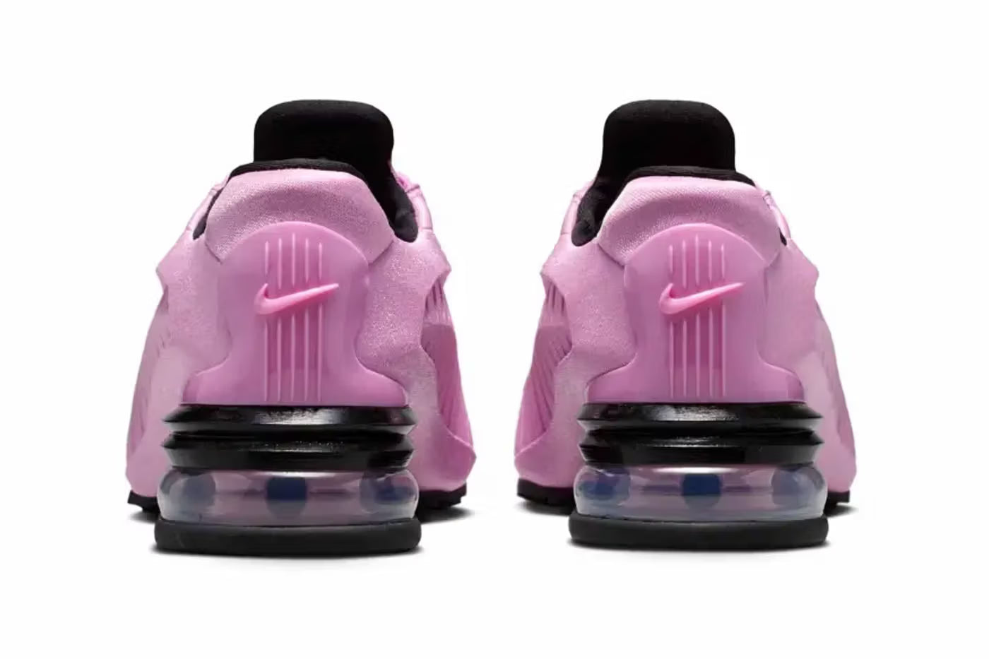 Back view of two Machina Wearable Technology Nike Air Max Dolce "Light Magenta" lifestyle sneakers featuring visible air-cushion soles, black heels, and the Nike swoosh logo on each heel, set against a plain white background.