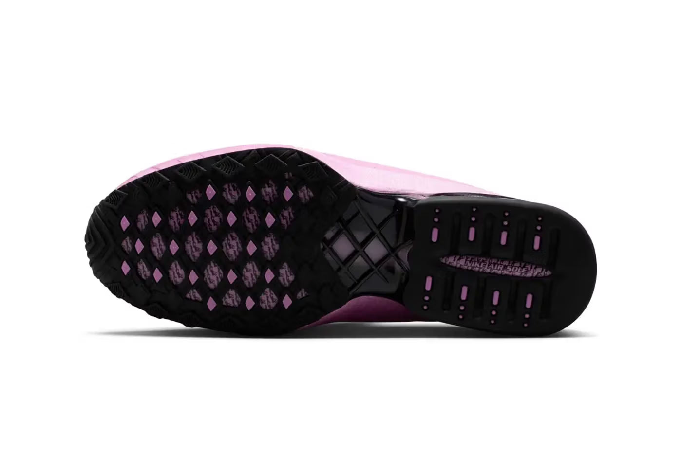 The image displays the black and purple patterned sole of a lifestyle sneaker from Machina Wearable Technology, seen from the bottom to emphasize its tread pattern for enhanced grip and traction. This distinctive outsole design reflects the "Light Magenta" colorway of the Nike Air Max Dolce.