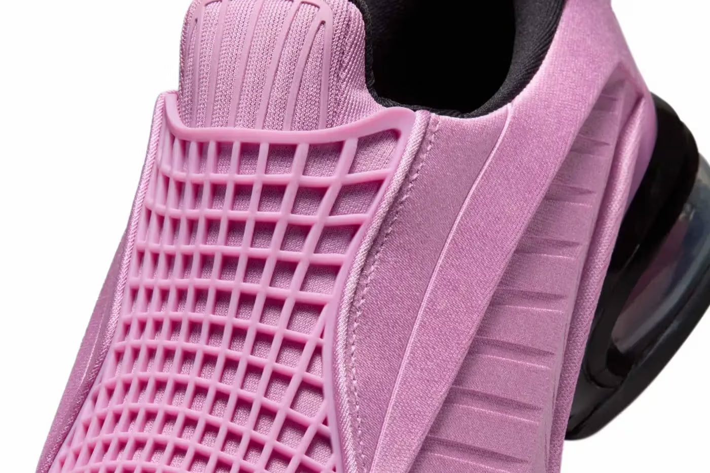 Close-up of the Machina Wearable Technology Nike Air Max Dolce "Light Magenta" lifestyle sneaker, showcasing a textured rubber grid overlay on the upper and a visible black air cushion in the heel.