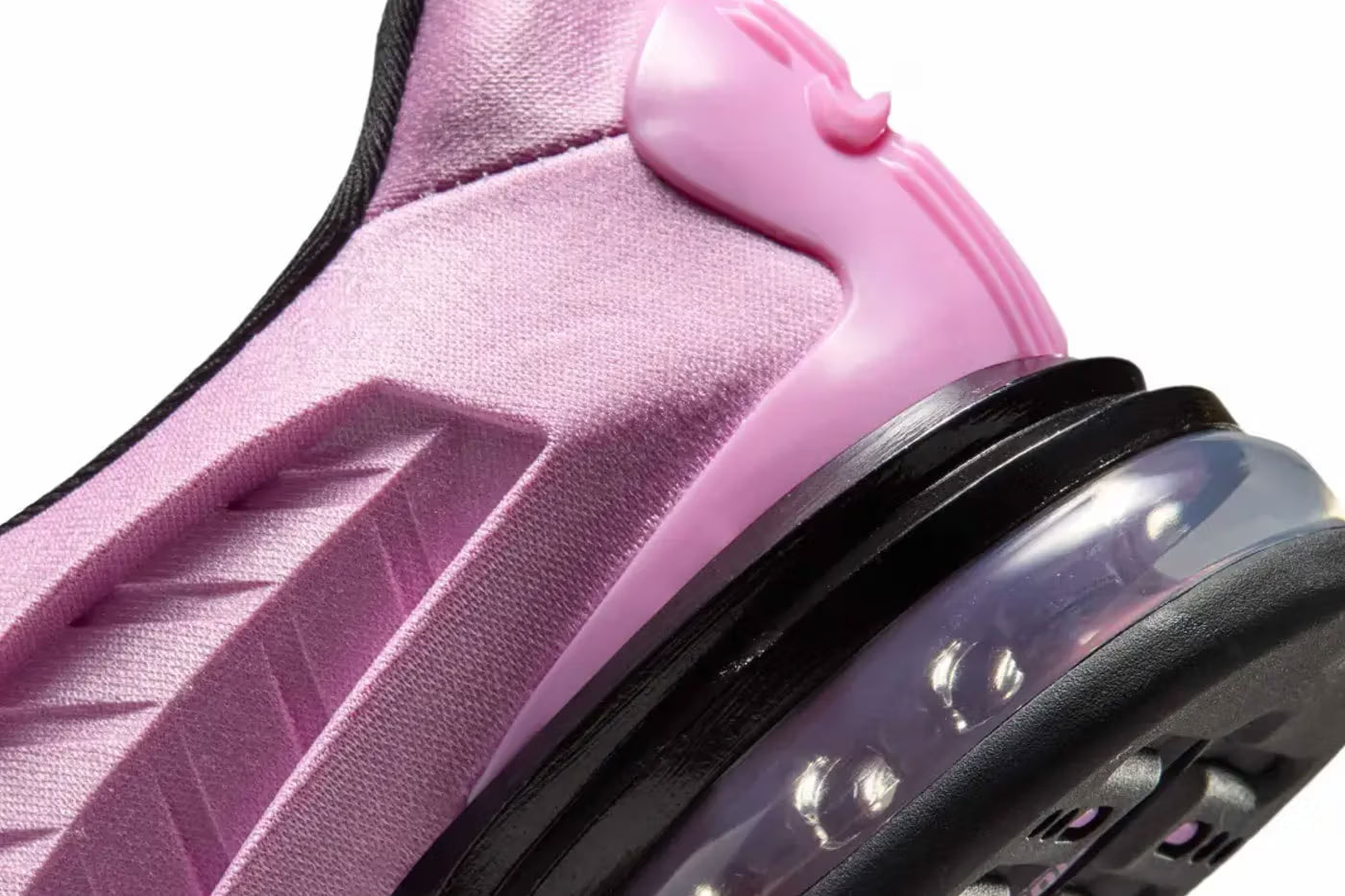 Close-up of the Machina Wearable Technology Nike Air Max Dolce "Light Magenta" sneaker, featuring a textured pink upper, black midsole, and a transparent air-cushion sole with visible bubbles.
