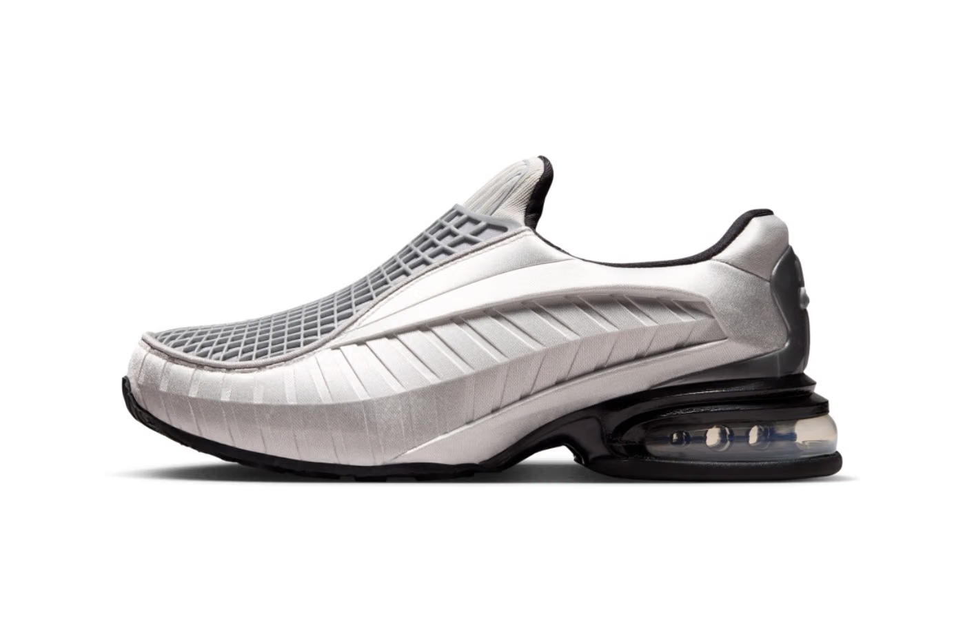 Introducing the Machina Wearable Technology Nike Air Max Dolce “Metallic Silver”: a slip-on lifestyle sneaker featuring a mesh upper with textured diagonal lines, a black sole, and a visible air cushion in the heel. Inspired by the iconic Nike Air Max Dolce design, its contemporary Metallic Silver finish defines this modern essential.