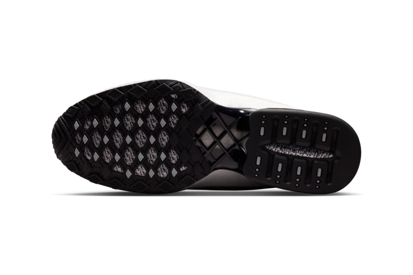 The image shows the black rubber outsole of the Nike Air Max Dolce “Metallic Silver” lifestyle sneaker by Machina Wearable Technology, featuring a diamond-shaped tread pattern and visible air cushioning units in the heel area.