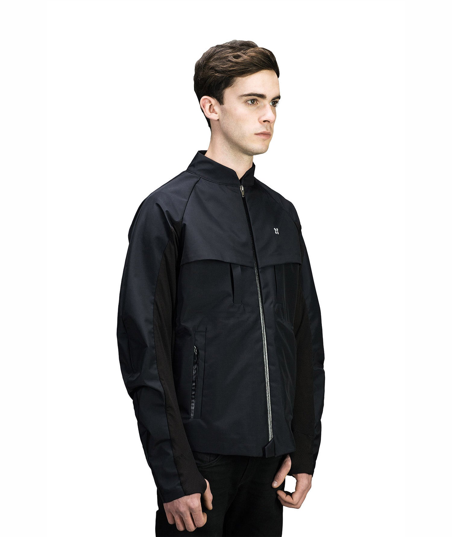 A person dressed in a MIDI Jacket by Machina - Wearable Technology, featuring a black zip-up design with a high collar, stands against a plain white background. The jacket has a modern look and subtle brand logo on the chest, integrating body sensors. The individual gazes forward with a neutral expression, prepared to create music on the go.