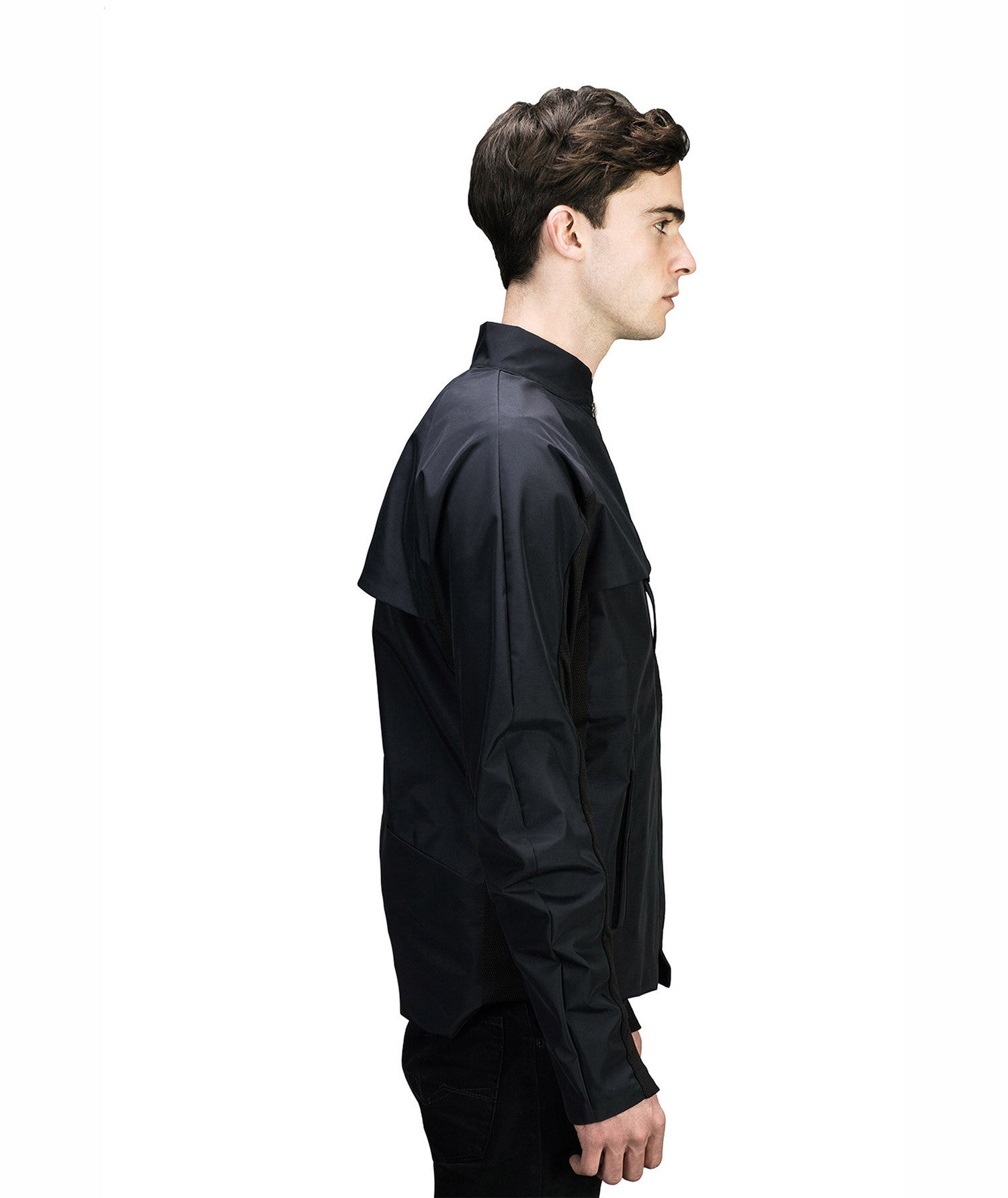 A person in profile models the MIDI Jacket by Machina - Wearable Technology. This sleek, dark-colored jacket features a high collar with integrated body sensors. Its minimalist design fits snugly, offering a modern and stylish look against an uncluttered white backdrop that emphasizes its innovative style.