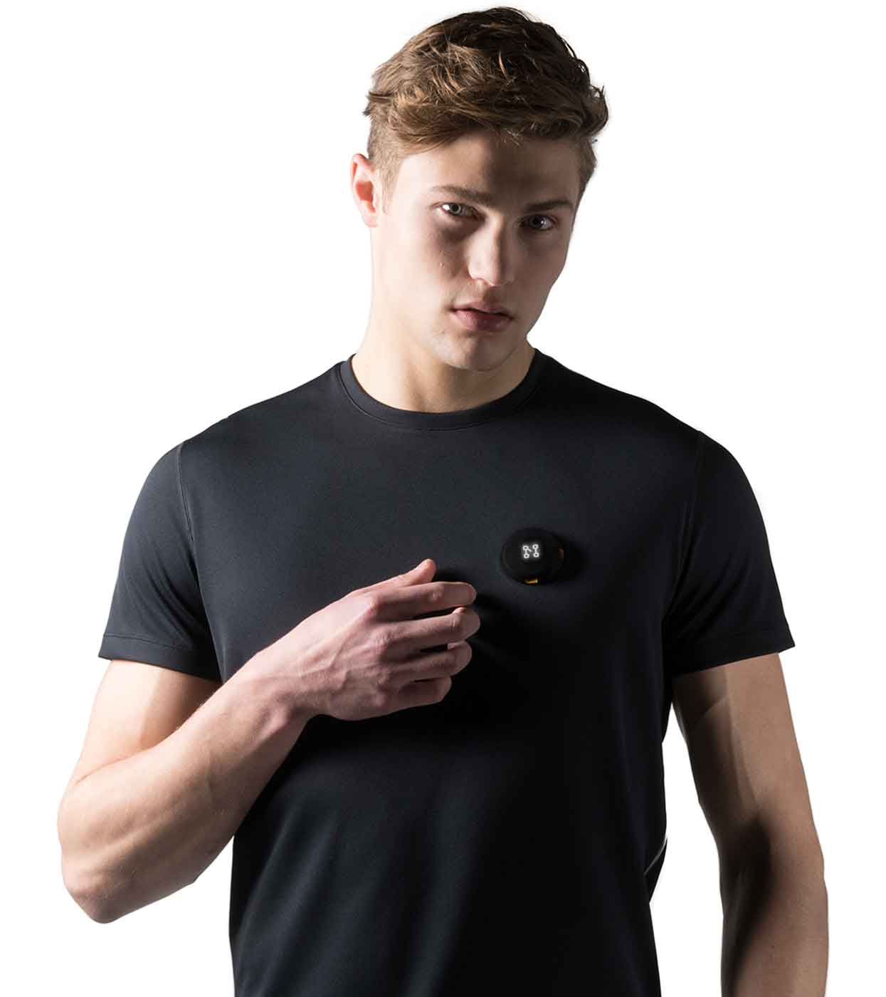 A person wearing Machina's Smart Black T-shirt, crafted from recycled polyester, holds a small black round device against their chest. The white background accentuates the individual and their eco-friendly choice, highlighting both style and sustainability.