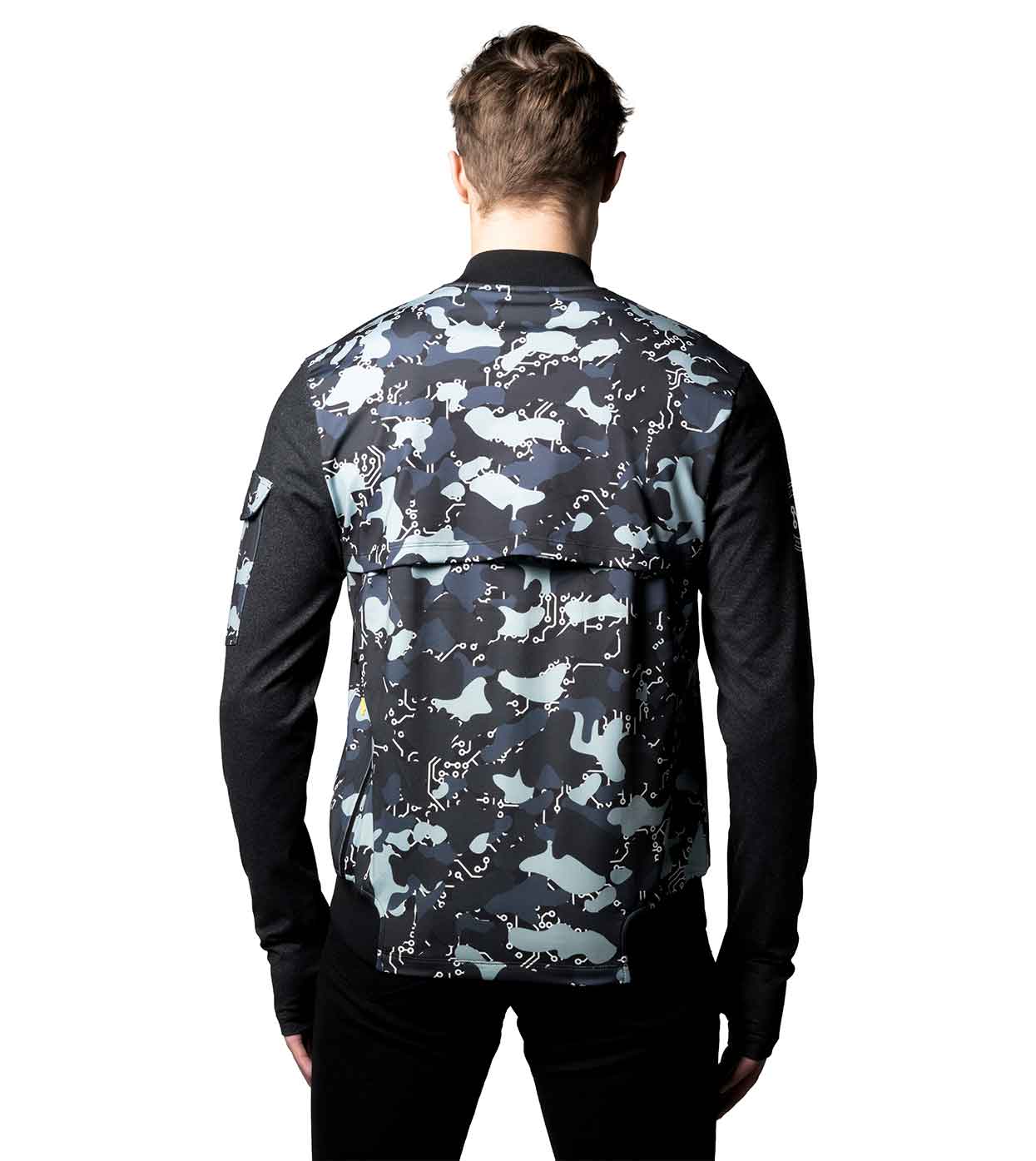 A person stands facing away from the camera against a white background, wearing a long-sleeved BLACK-CAMO BOMBER JACKET by Machina - Wearable Technology, featuring a camo pattern in black and gray with solid black sleeves.