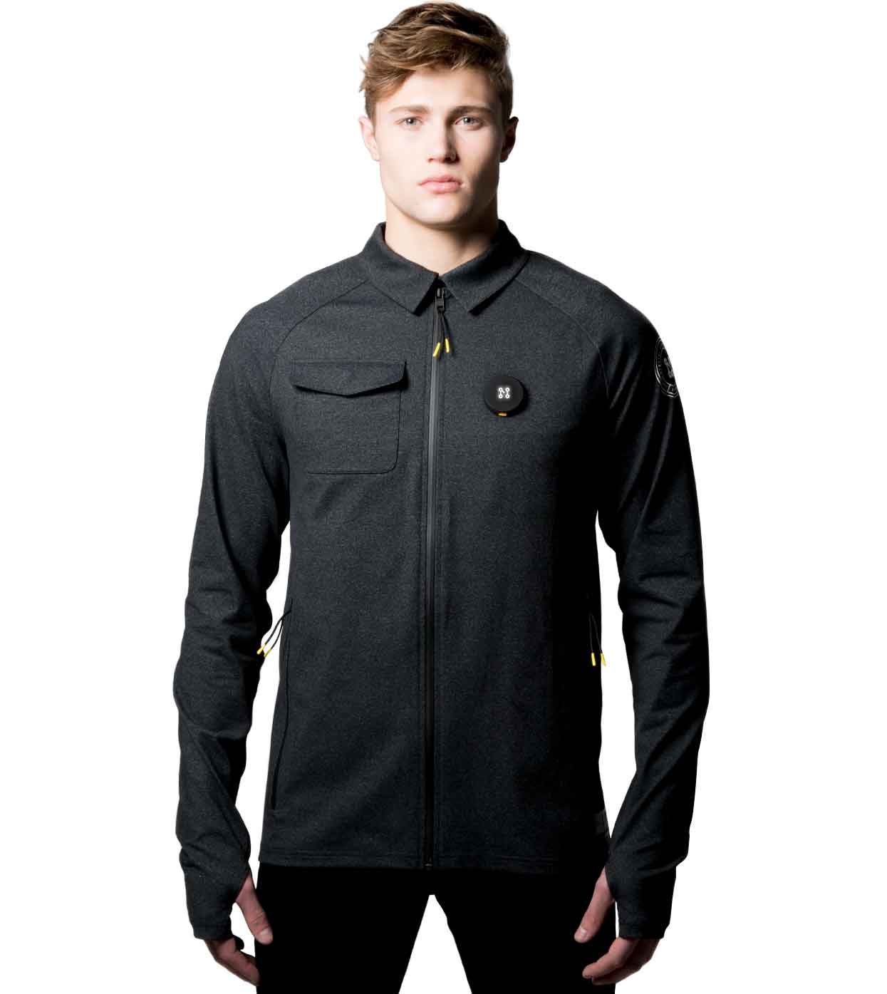 A person wearing the BLACK CASUAL JACKET from Machina - Wearable Technology stands facing the camera. This black jacket is equipped with a front zipper, a buttoned pocket on the left side of the chest, and bears a small circular logo on the right side, showcasing cutting-edge fashion technology against a plain white background.
