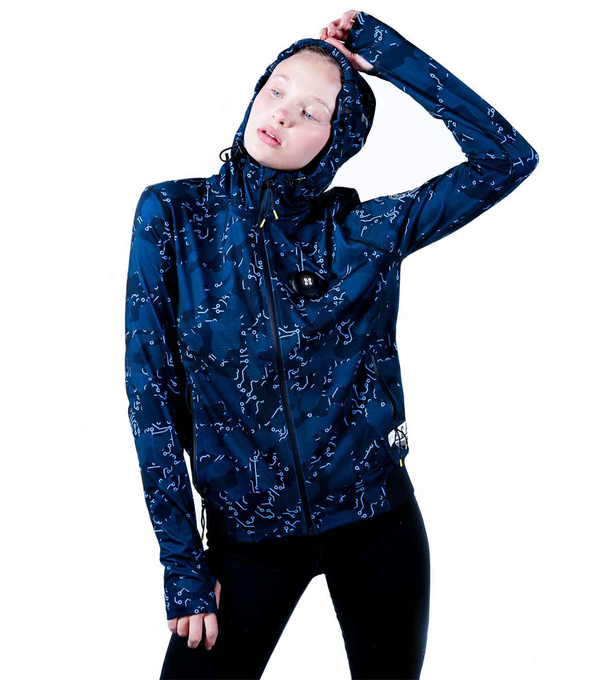 A person models in Machina - Wearable Technology's ELECTRIC BLUE HOODIE paired with black leggings, striking a pose with one hand on their head. This high-tech hoodie showcases abstract white designs and includes a front zipper, all set against a plain white background.